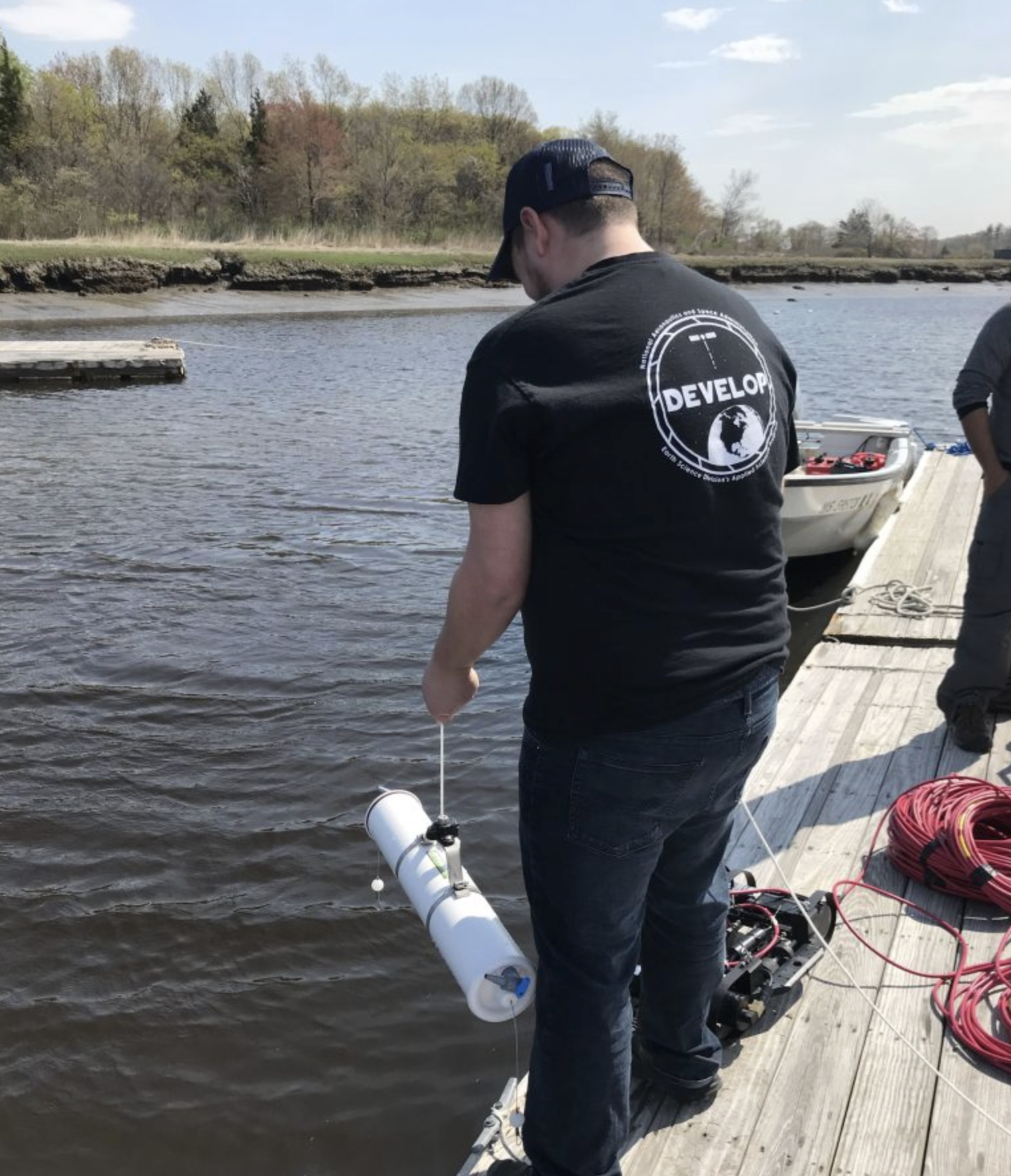 ZachBengtsson_Watersamples Zach Bengtsson standing on the dock gathering water samples