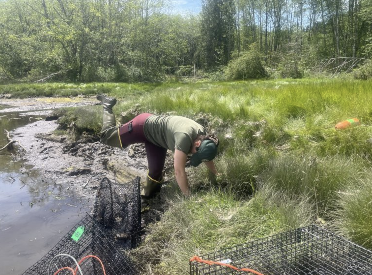 Lennah Mohar leans over with her leg in the air and empties her hip wader of water.<br />

