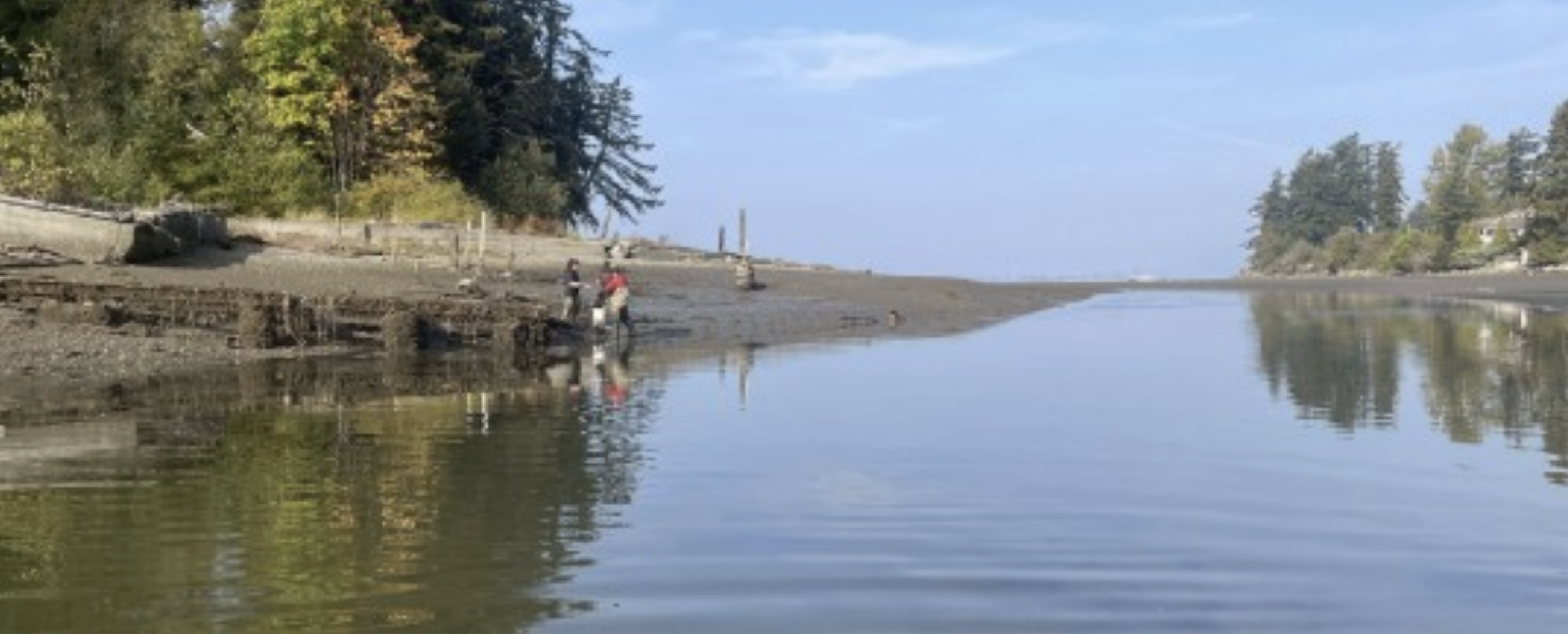 Two trappers check a trap by the shore