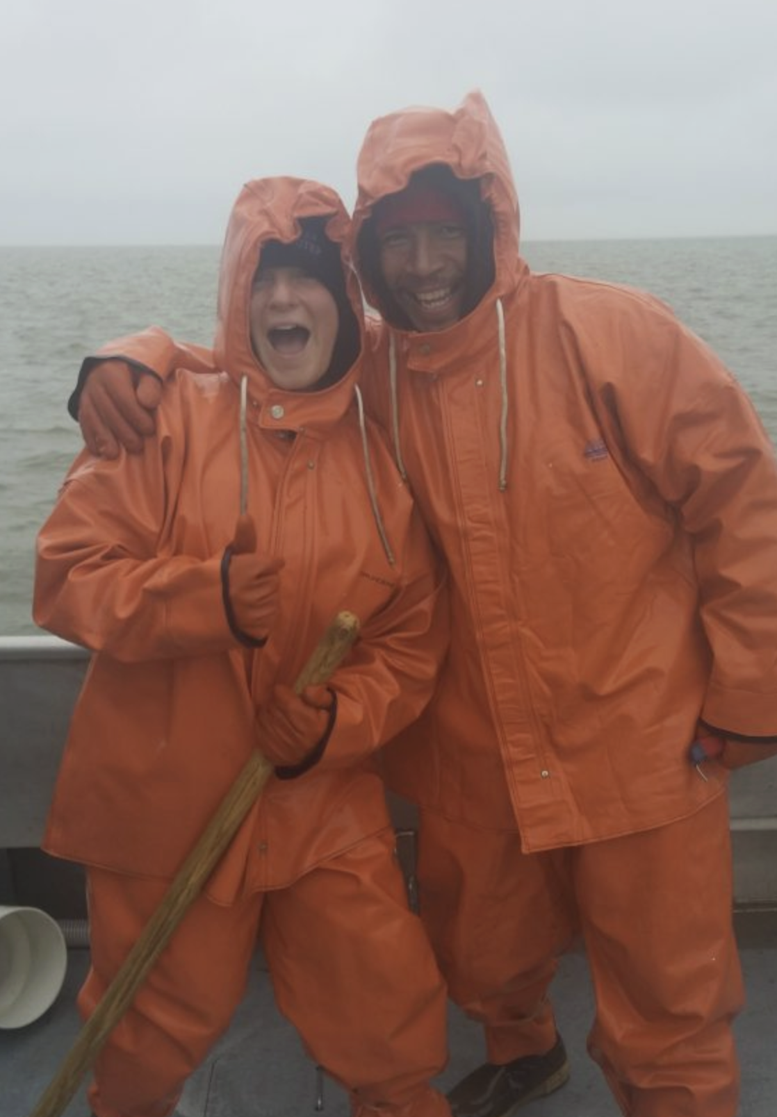 Alex Stote and colleague wearing orange suits on a boat